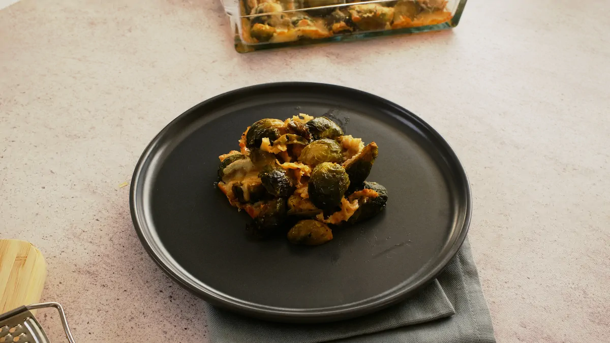 Cheesy keto Brussels sprouts casserole served on a dark grey plate.