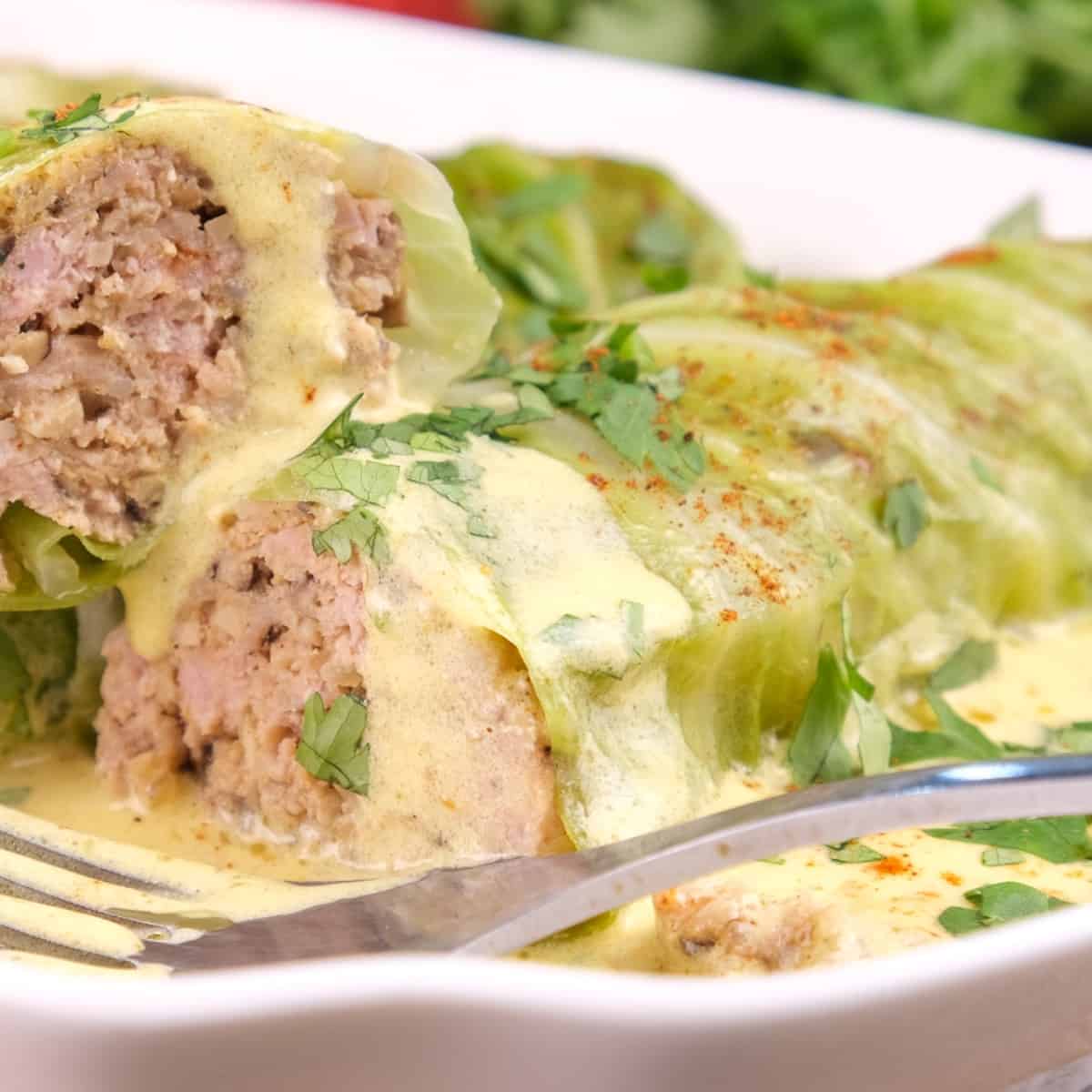 A close-up of sliced keto cabbage rolls, showing the pork filling inside.