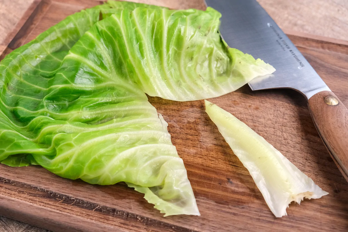 Trimming the tough white parts of cabbage leaves in a v-shape.