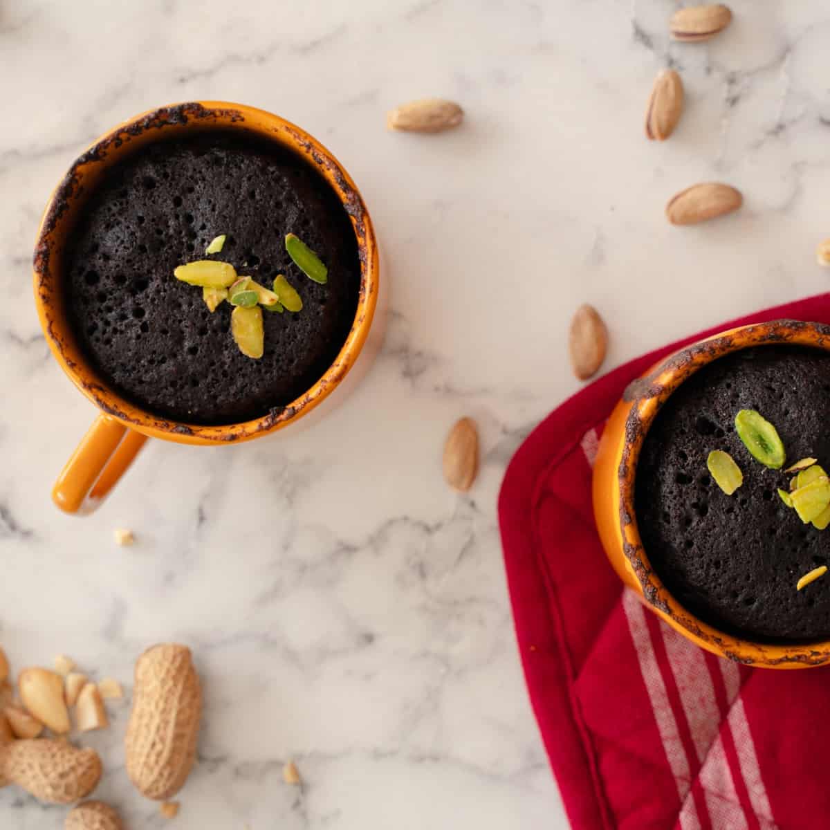 Homemade keto chocolate mug cake garnished with nuts.
