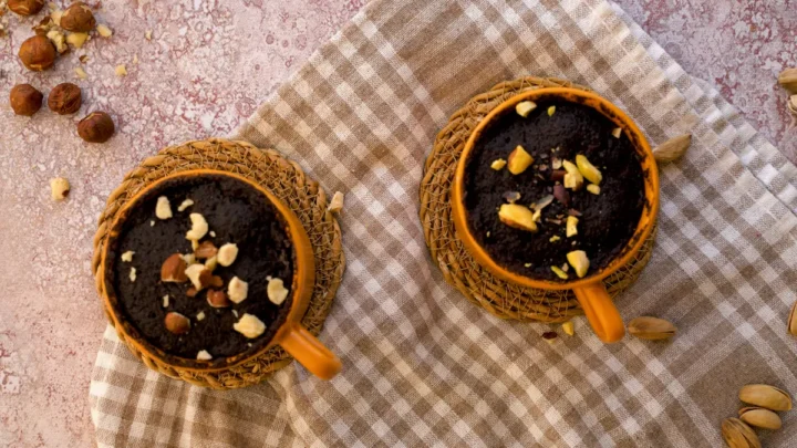Keto chocolate mug cake garnished with nuts ready to be devoured.
