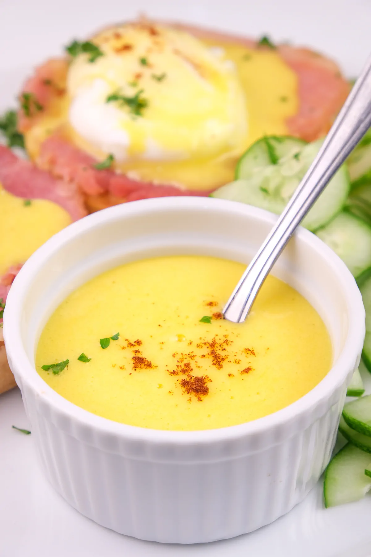 A focused shot of keto hollandaise sauce in a bowl with a spoon.
