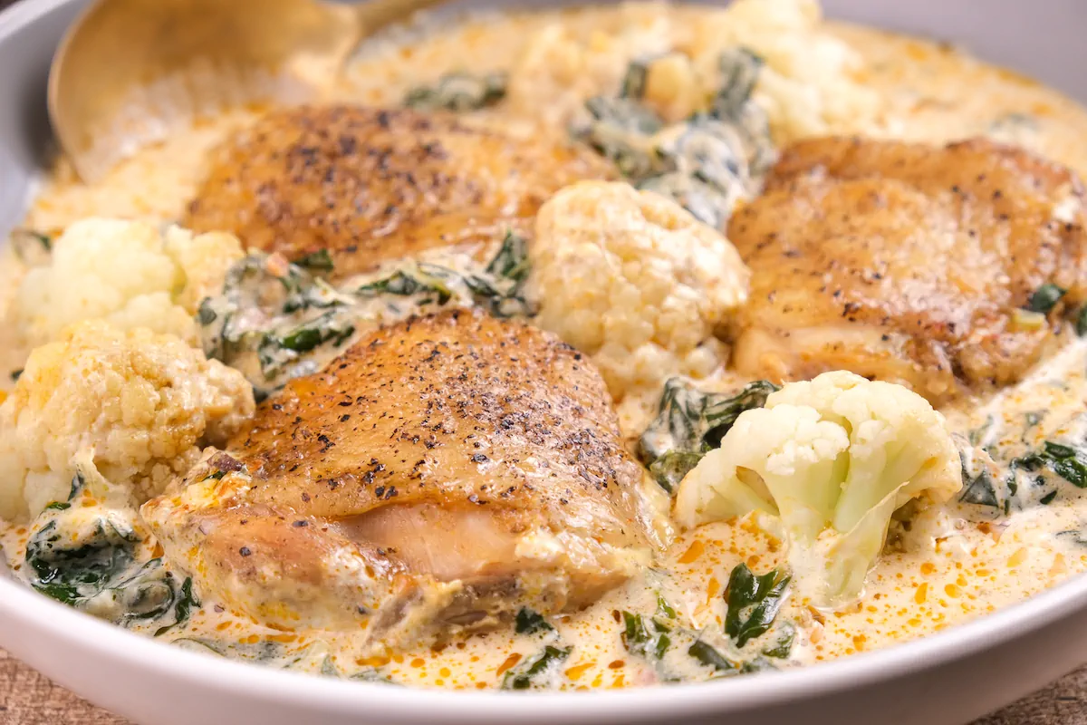 A close-up shot of keto pesto chicken served in a bowl.