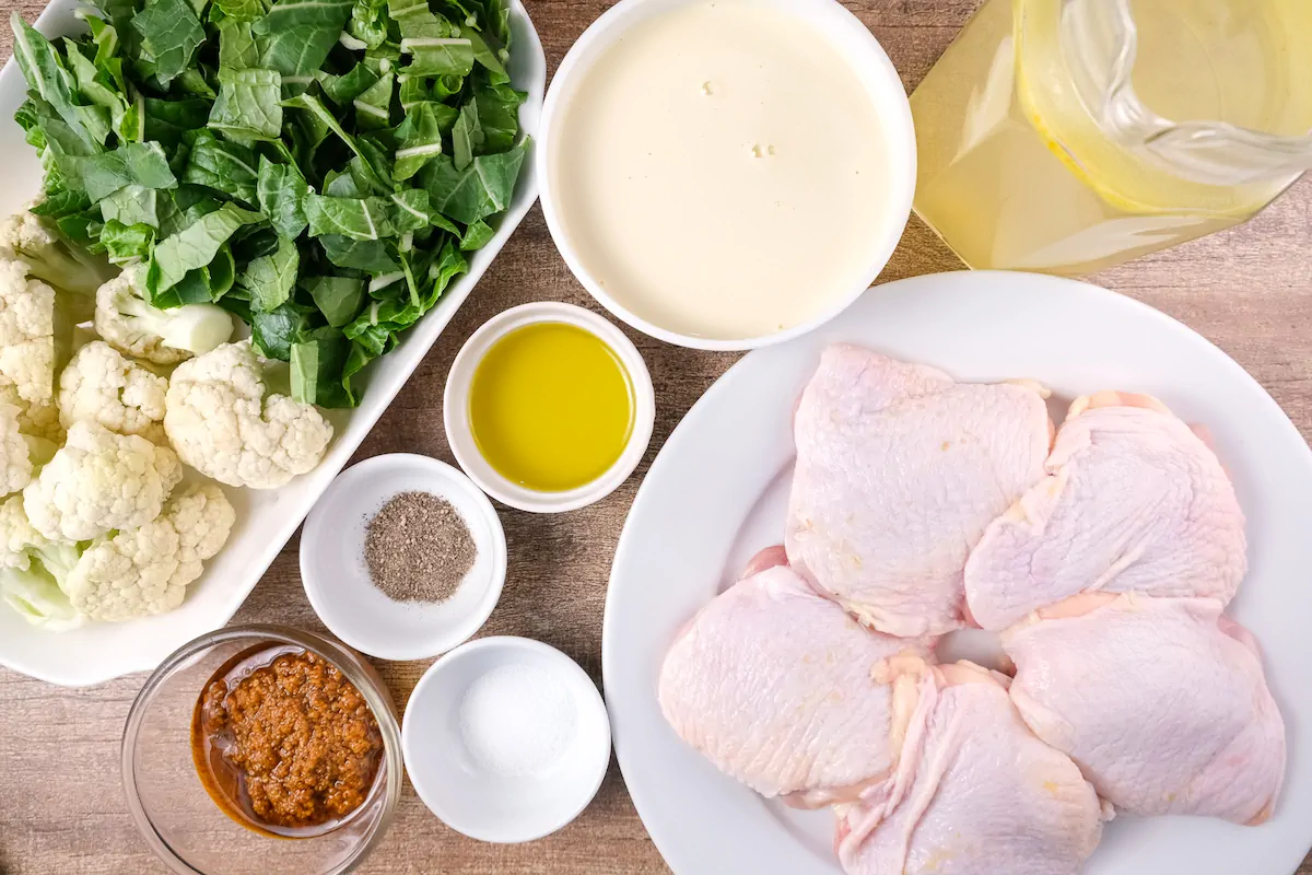 All the ingredients required to make keto pesto chicken are gathered and displayed on the table.
