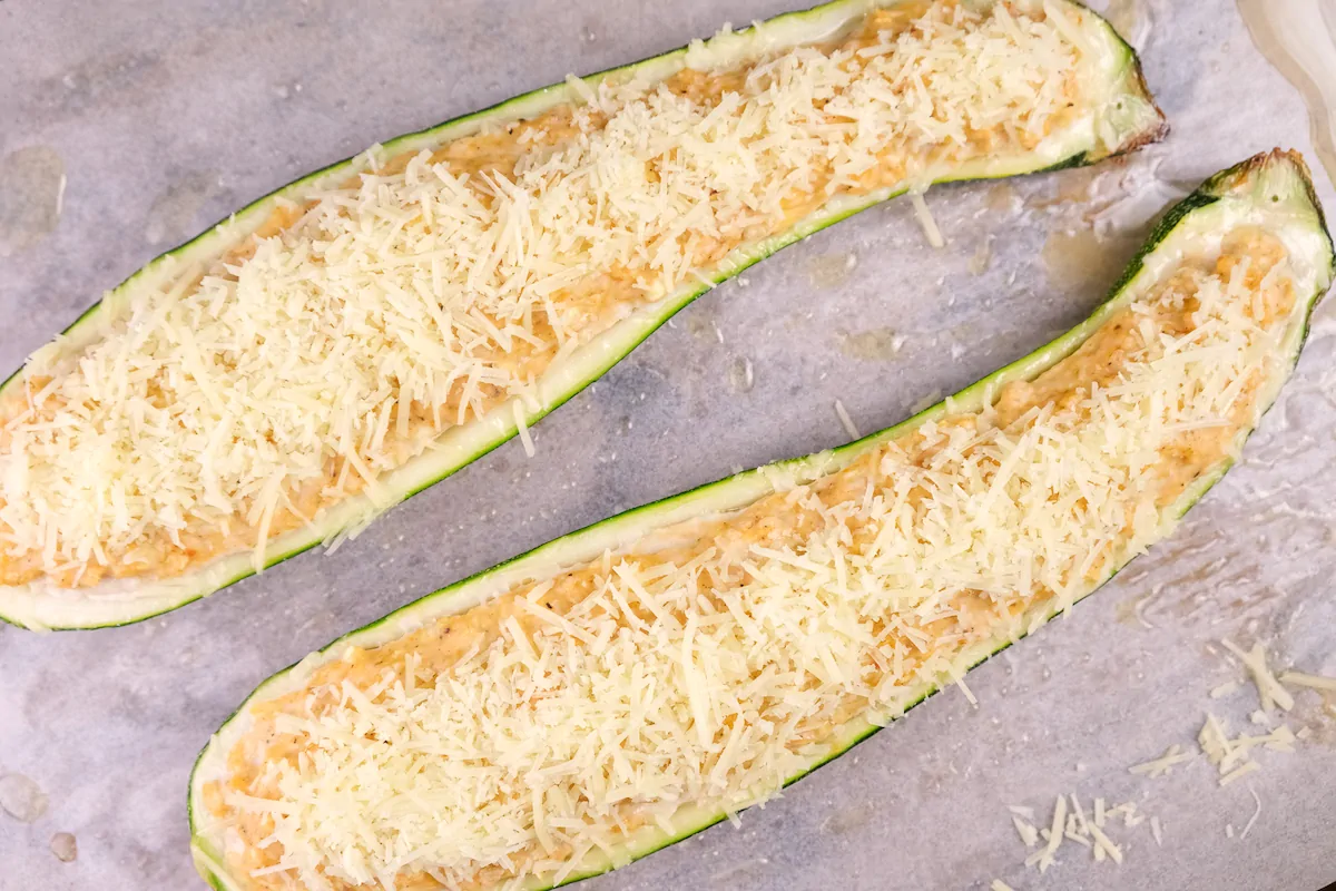 Cheese sprinkled on top of the zucchini boats.