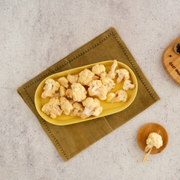 Easy pickled cauliflower served on a yellow oblong tray.