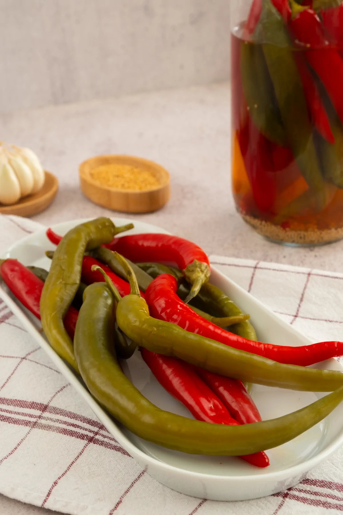 Pickled peppers served on a plate from a jar of pickles.