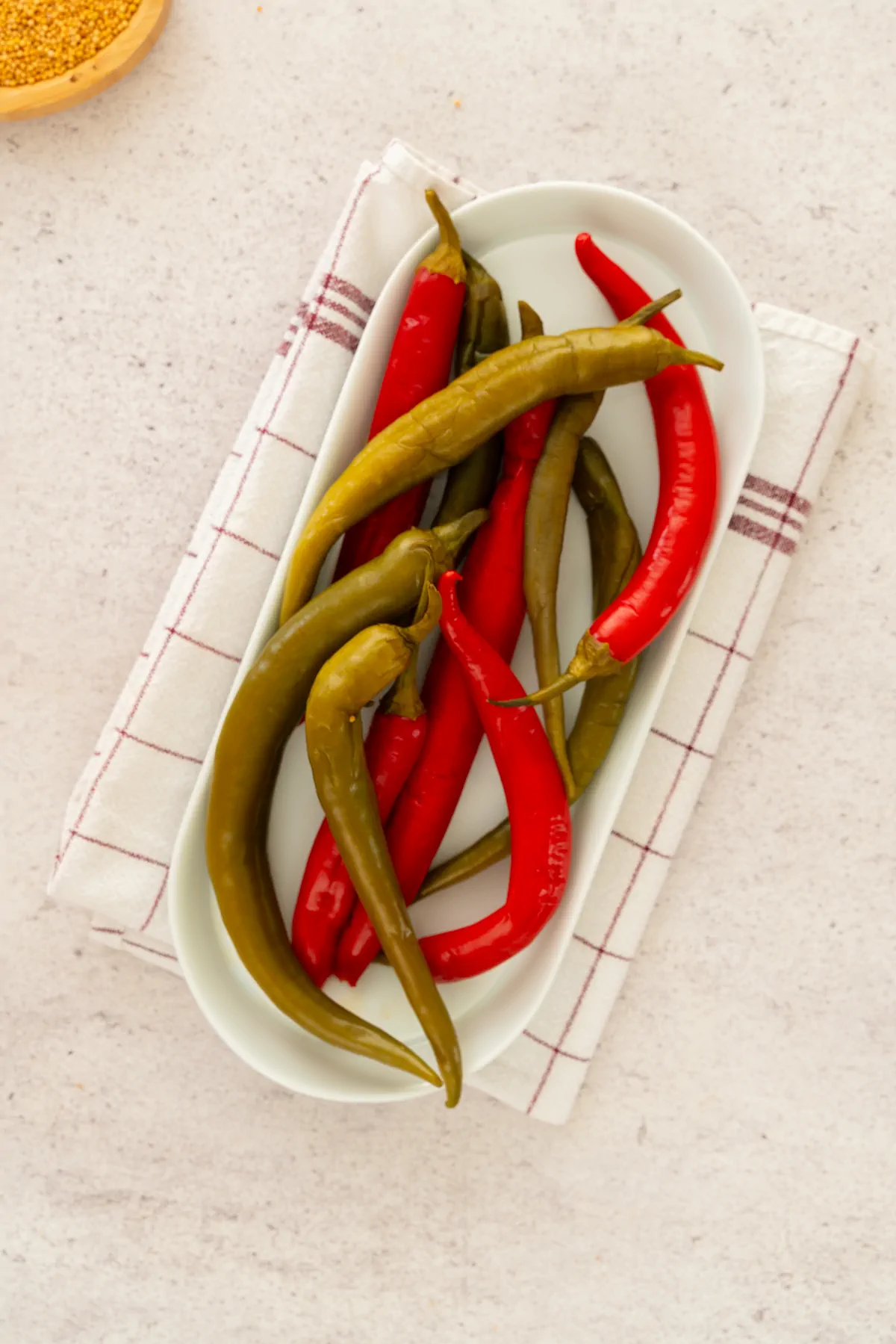 Homemade pickled peppers served on a plate.