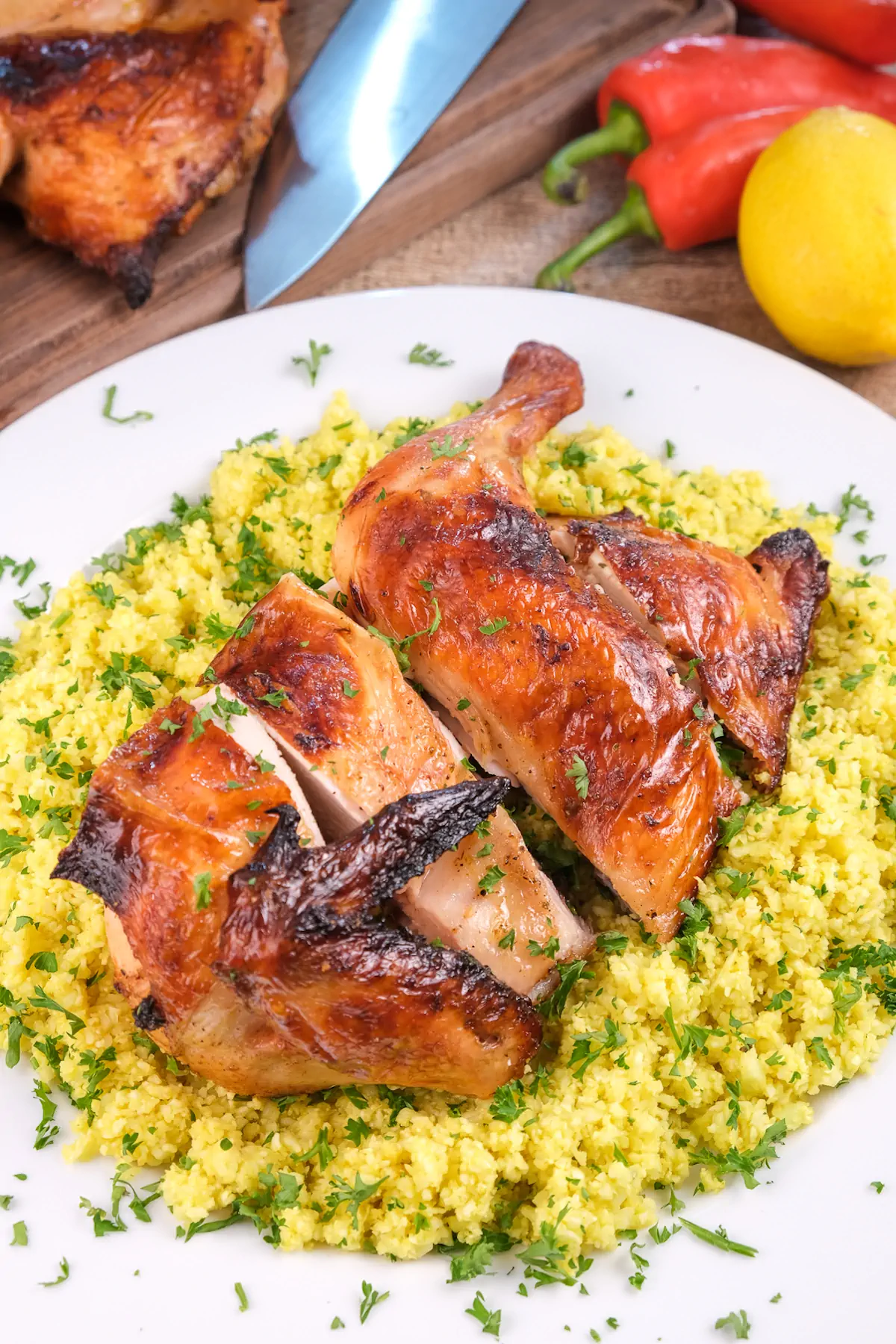 Pollo asado served with cauliflower rice and fresh herb garnish.