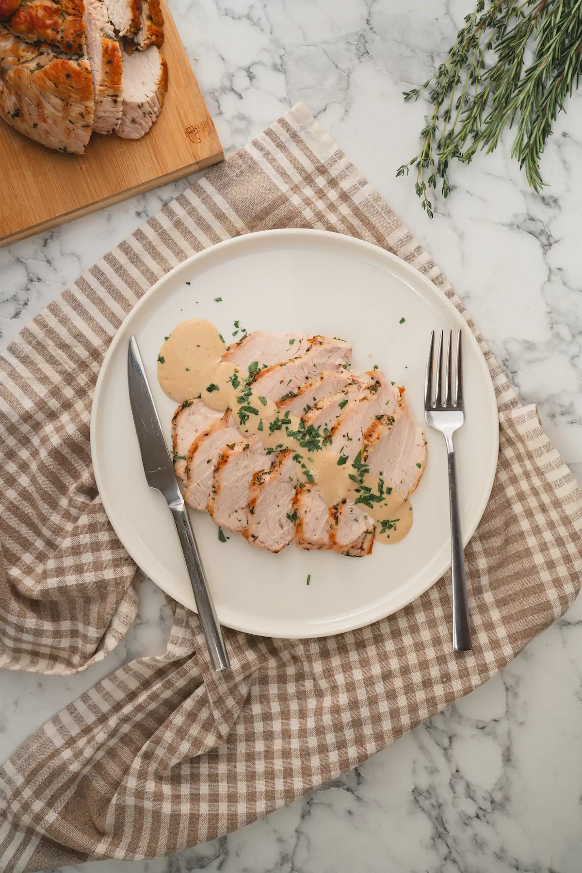 Slices of roasted turkey breast, served with keto gravy on a plate.
