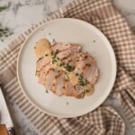 Roasted turkey breast slices with keto gravy, served on a plate.