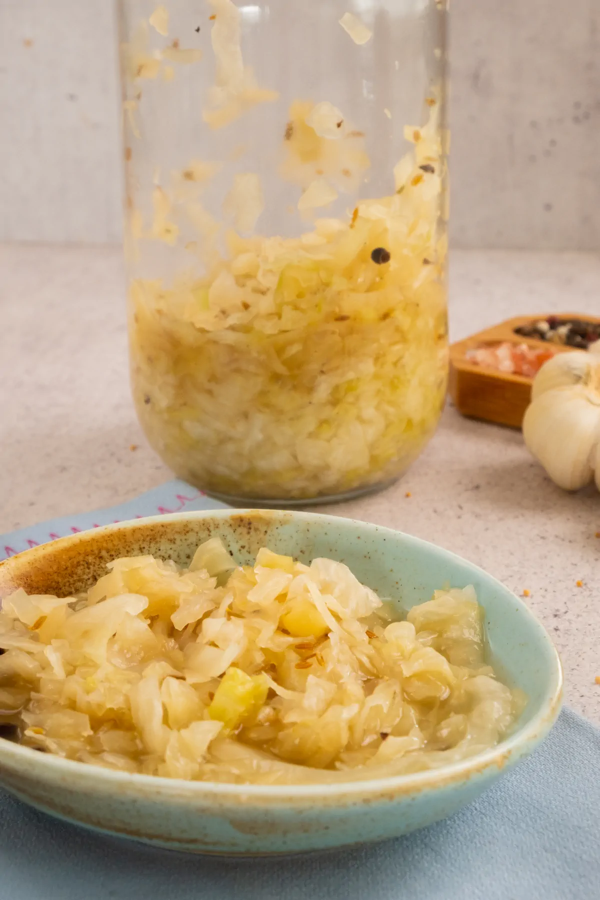 Homemade sauerkraut served in a ceramic bowl from a glass jar.