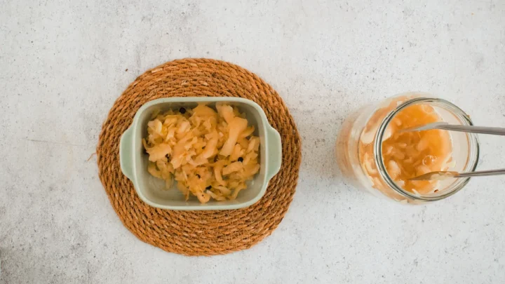 Serving the sauerkraut in a ceramic bowl with tongs from a glass jar.