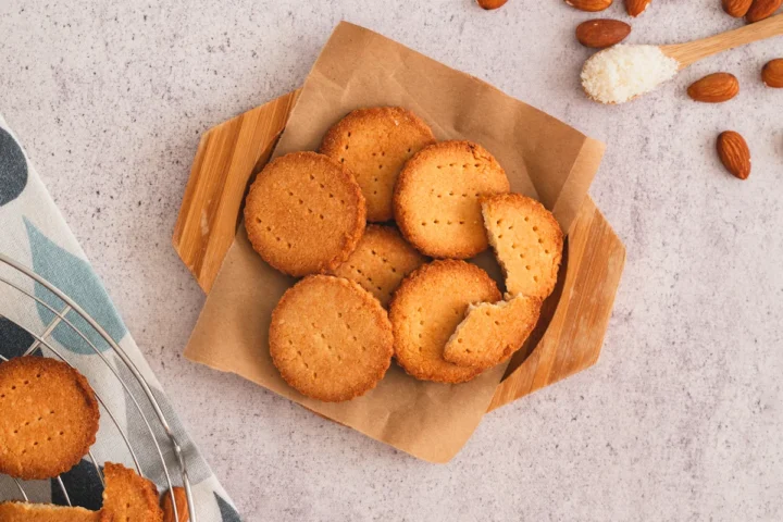 Homemade almond flour shortbread cookies are presented on a wooden plate.