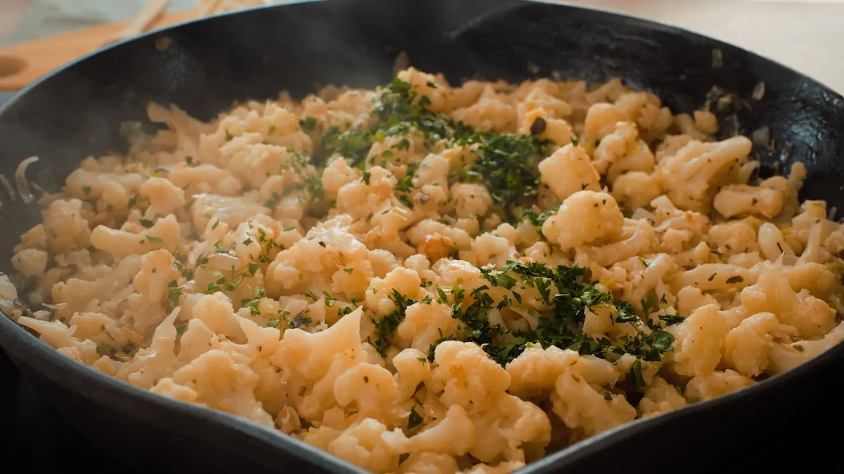 Cauliflower stuffing sprinkled with freshly chopped parsley in a cast iron skillet.