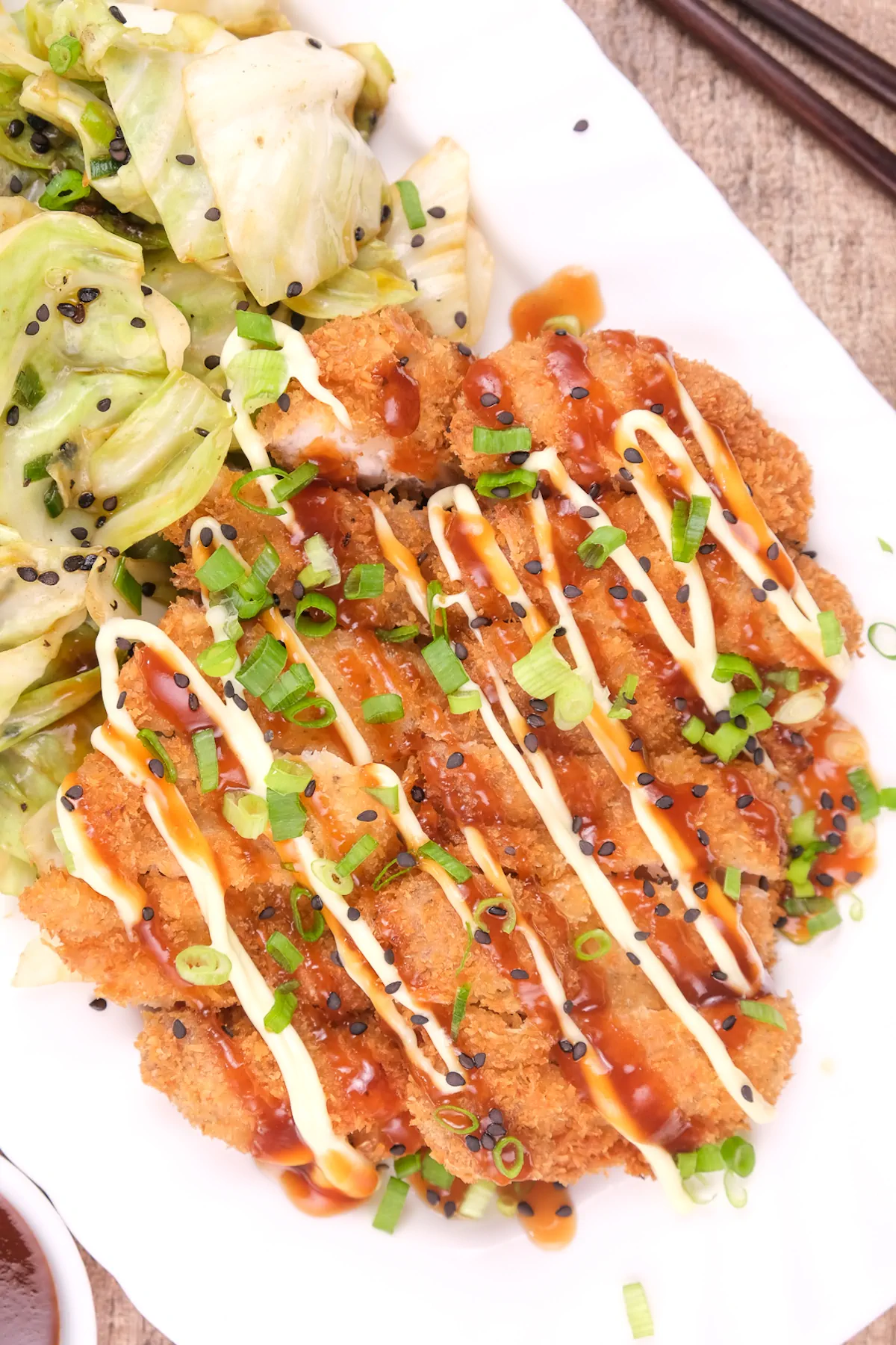 Fried chicken slices with Japanese mayonnaise and katsu sauce on top.