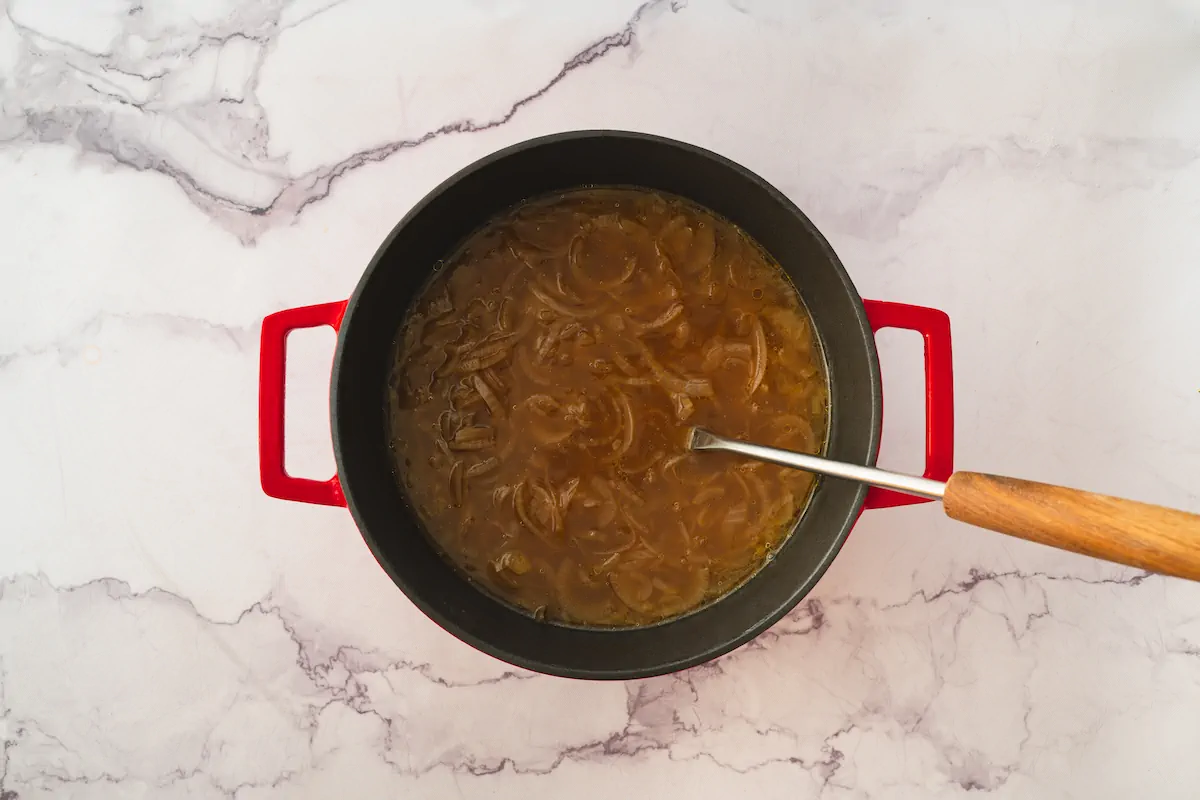 Keto French onion soup in a pot with a ladle ready to be served.