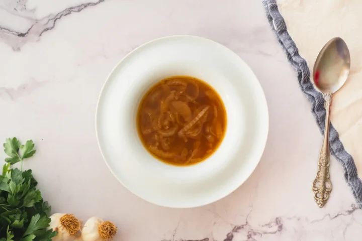 Keto French onion soup in a bowl with a spoon.