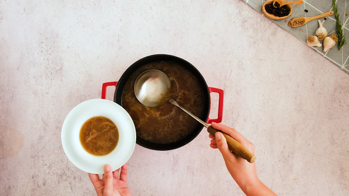 Pouring the keto French onion soup to a bowl with a ladle.