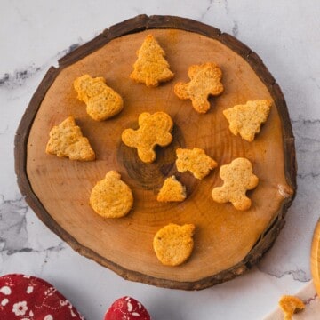 Keto gingerbread cookies of different shapes arranged on a wooden board.