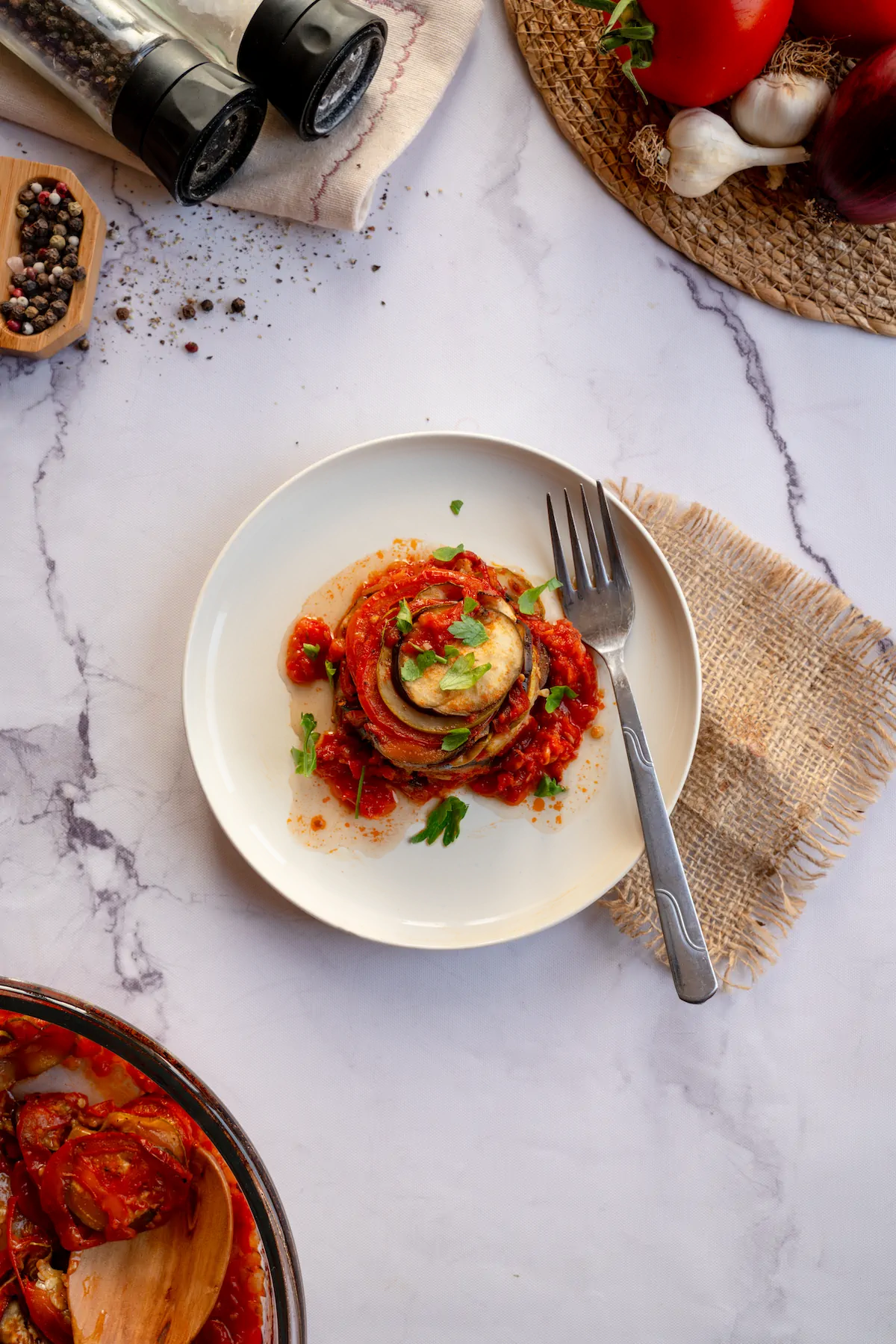 Keto ratatouille served on a plate and garnished with fresh herbs.
