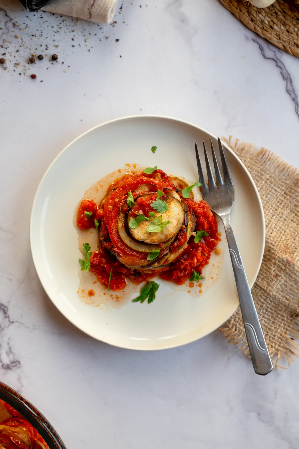 Homemade keto ratatouille presented on a plate and garnished with fresh herbs.
