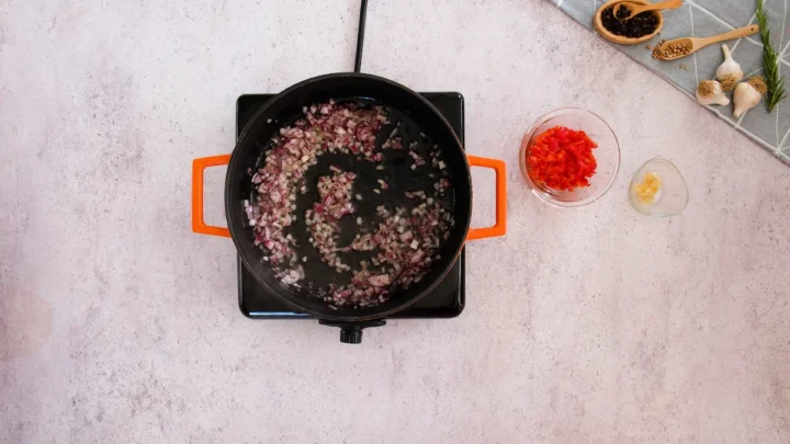 Sautéing the diced onions in a cast iron skillet.