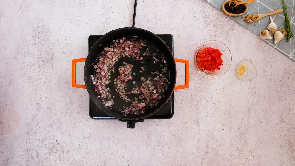 Sautéing the diced onions in a cast iron skillet.
