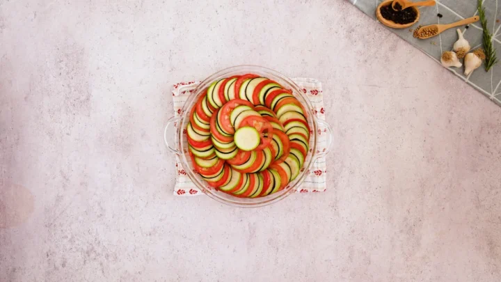 Keto ratatouille arranged and layered with sliced egg plant, tomato and zucchini.