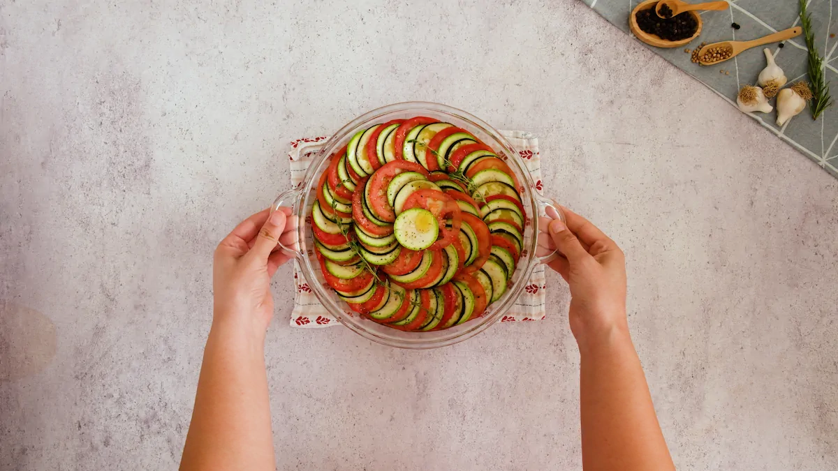 Keto ratatouille topped with olive oil, fresh thyme, sea salt and pepper ready to be baked.