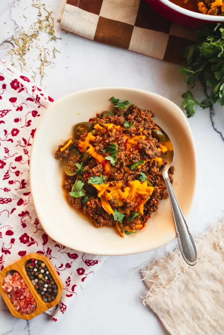 In a bowl, a homemade keto Tex-Mex casserole is served alongside a spoon.