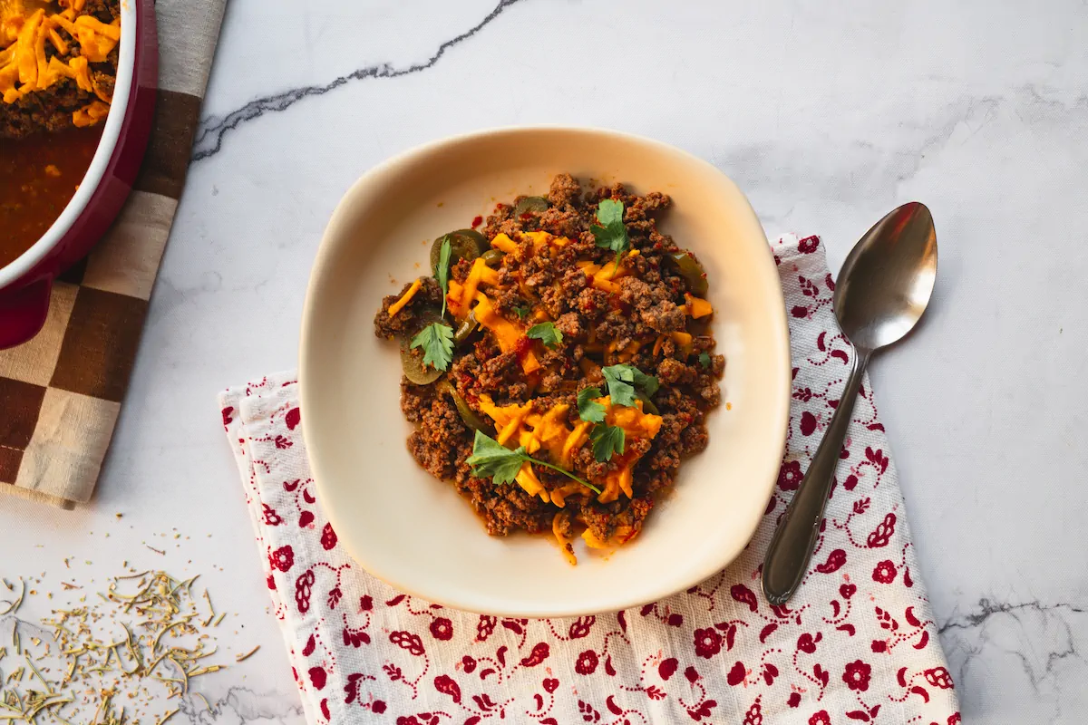 Homemade keto Tex-Mex casserole served in a bowl alongside a spoon.