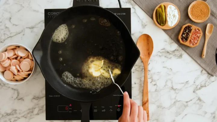 Butter melting in a heated cast iron skillet.