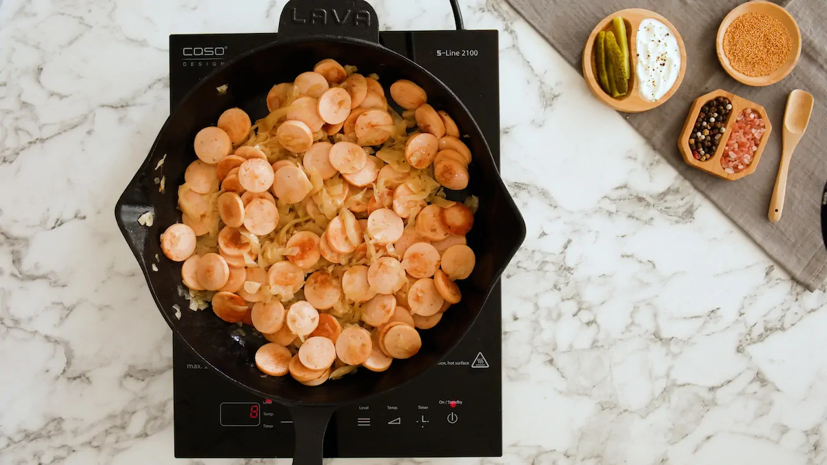 Sausage and sauerkraut cooking in a cast iron skillet.