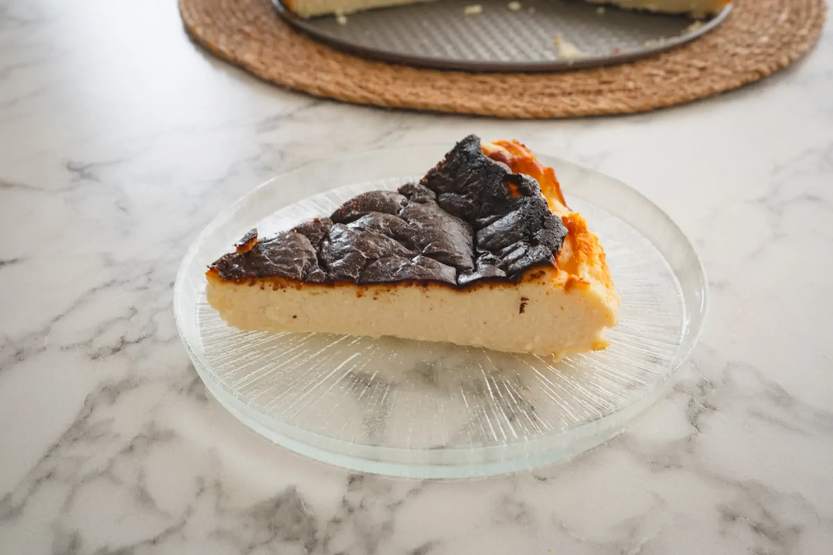 A slice of burnt Basque cheesecake is served on a plate.