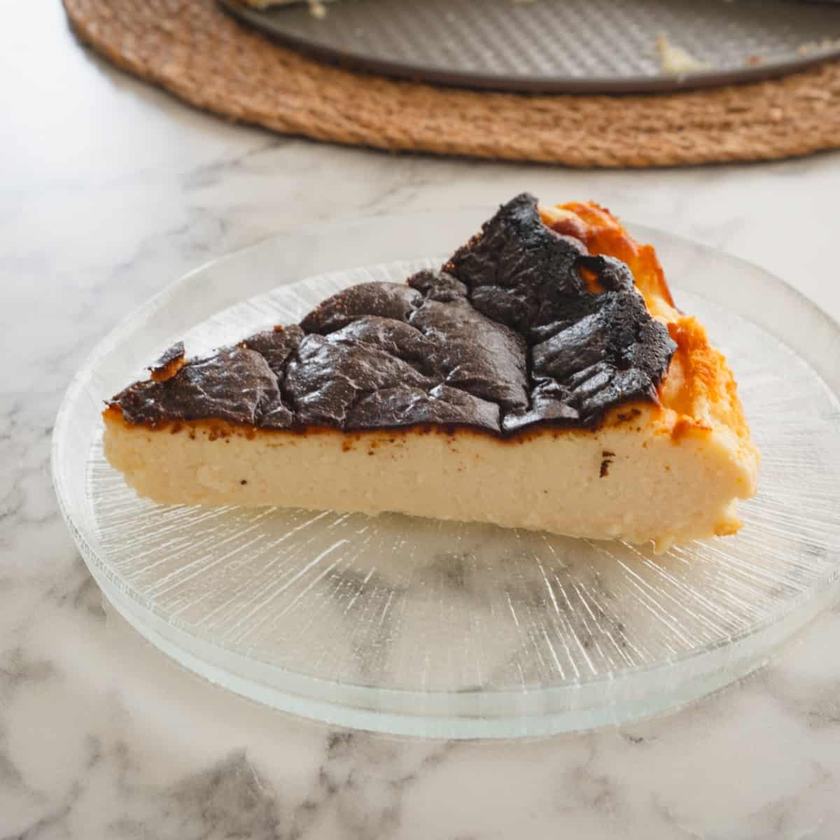 A slice of sugar-free keto Basque cheesecake served on a glass plate.