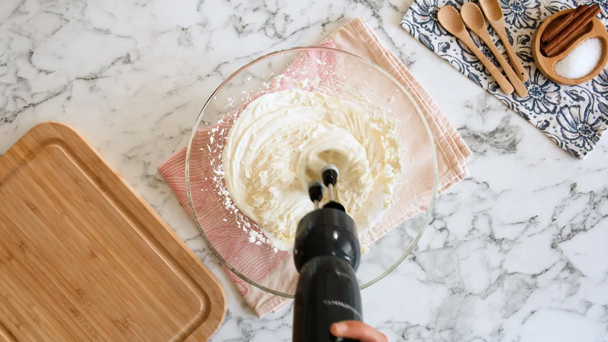 Blending softened cream cheese and monk fruit sweetener with an immersion blender.