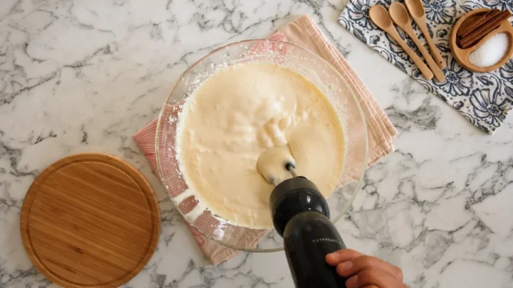 Mixing sugar-free cheesecake in a bowl with an electric hand mixture.