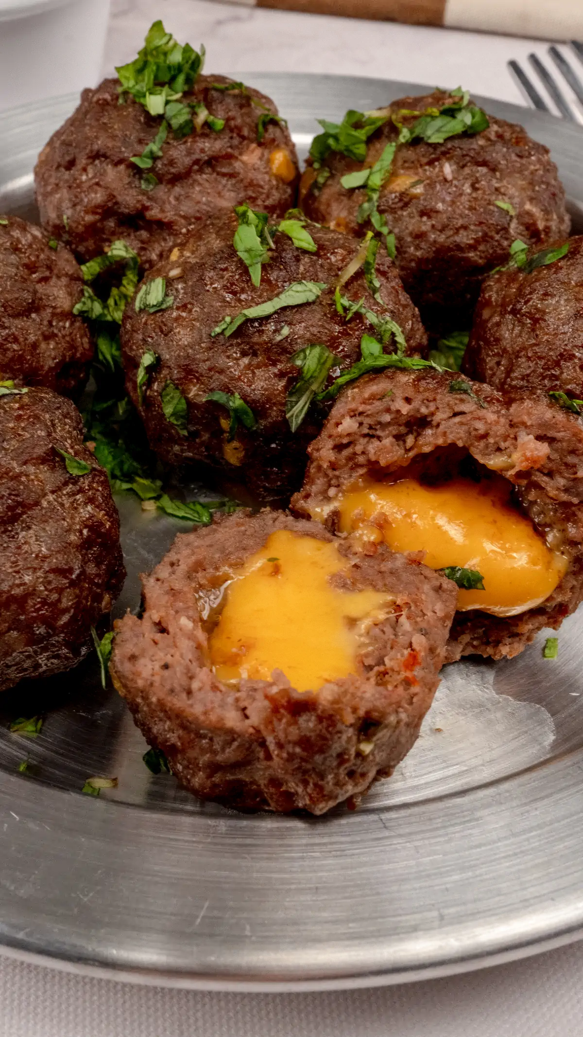 A focused shot of meatballs filled with cheese.