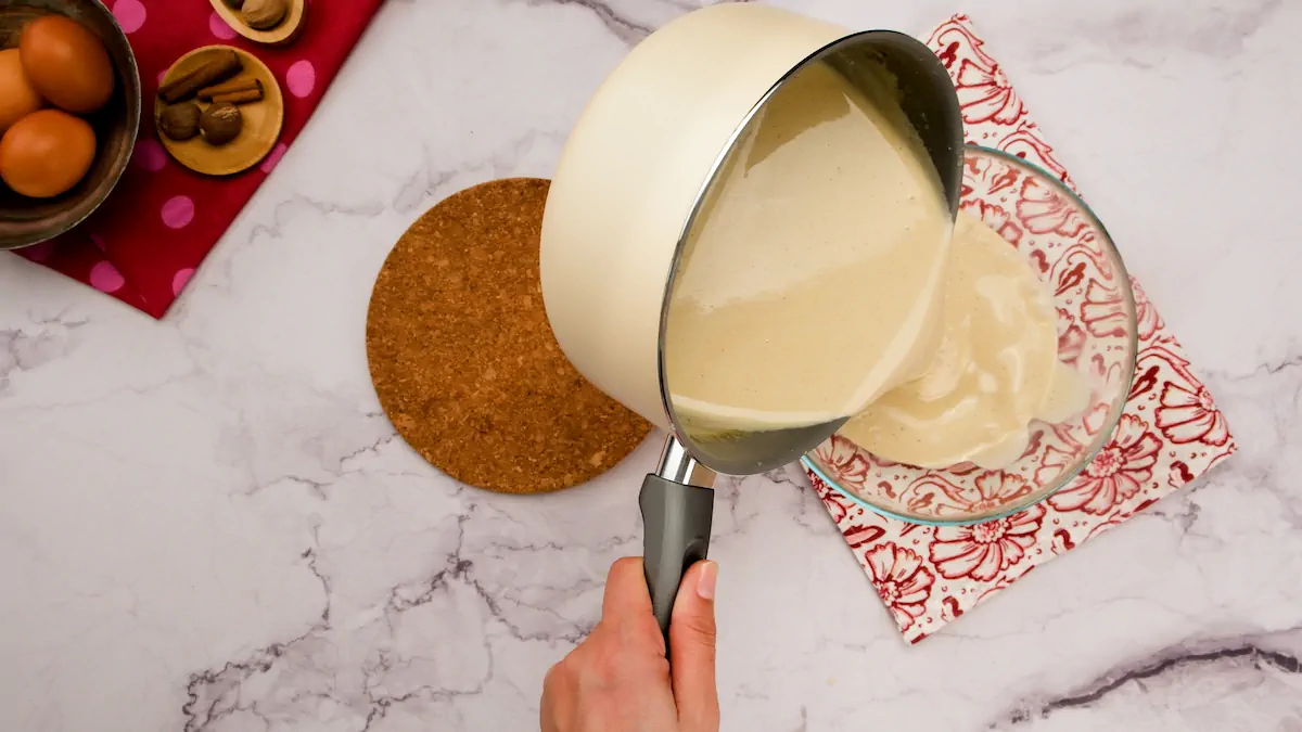 Pouring the eggnog mixture into a transparent glass bowl.