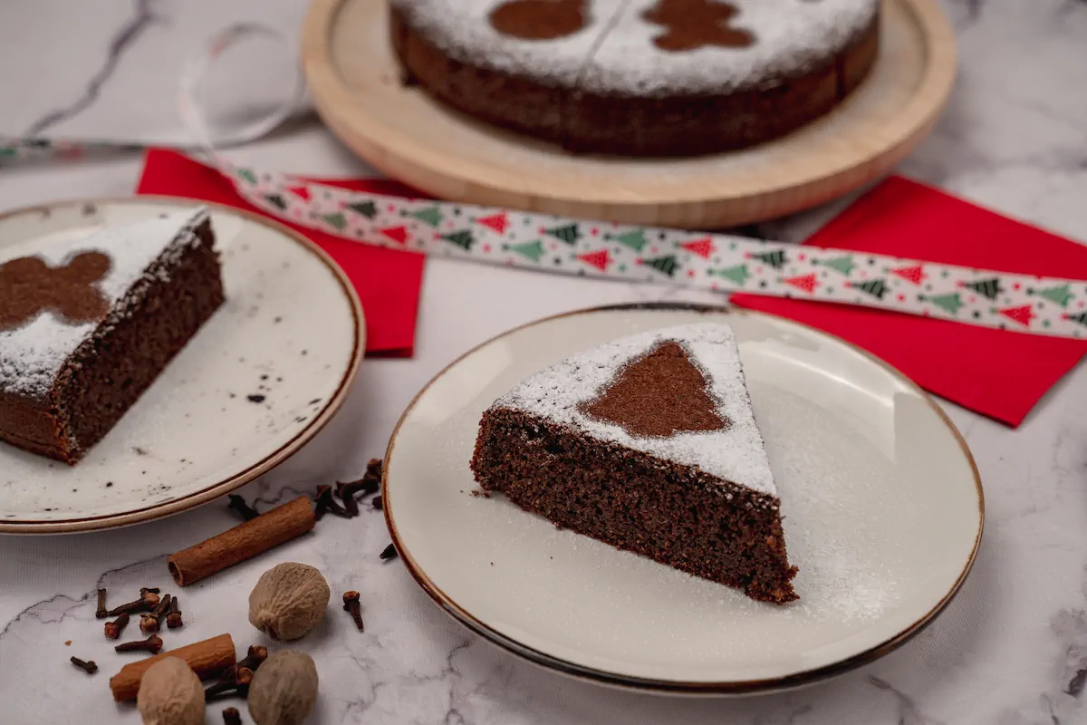 Homemade keto gingerbread cake presented on two plates and sprinkled with powdered erythritol.