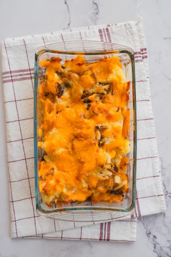 Freshly baked low-carb loaded cauliflower casserole in a rectangular glass baking dish.