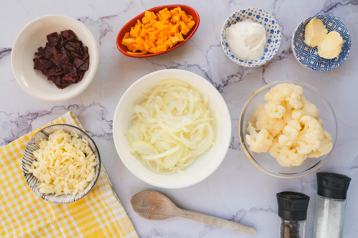 All the ingredients required to make keto loaded cauliflower casserole arranged and displayed on the table.