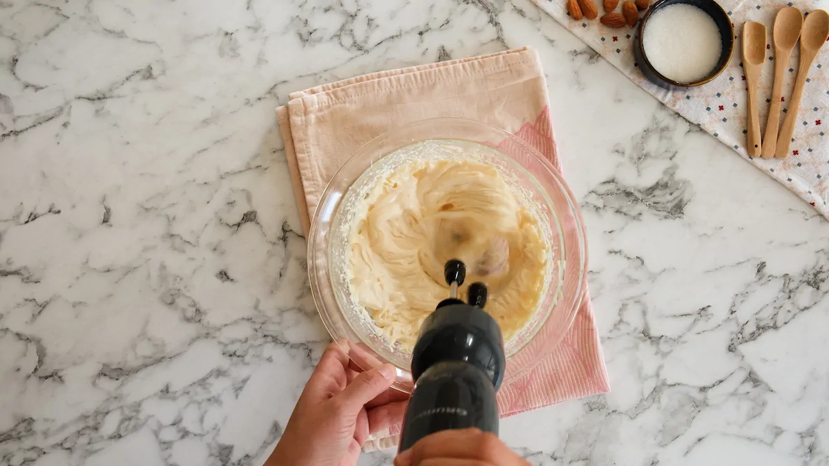 Mixing cream cheese and sweetener for cheesecake filling with a hand mixer.