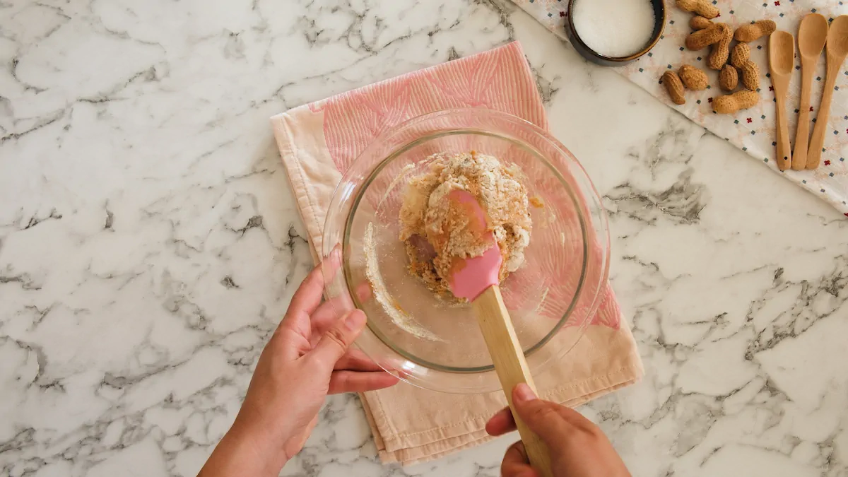 Mixing all the ingredients for no-bake coconut cookies in a transparent bowl with a silicone spatula.