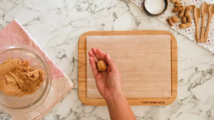 Portioning no-bake coconut cookie dough with a hand.