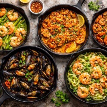 ssortment of keto seafood skillet dinners with shrimp, salmon, mussels, and zucchini noodles